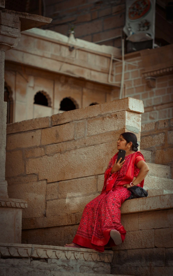 A woman in a red dress sitting on steps